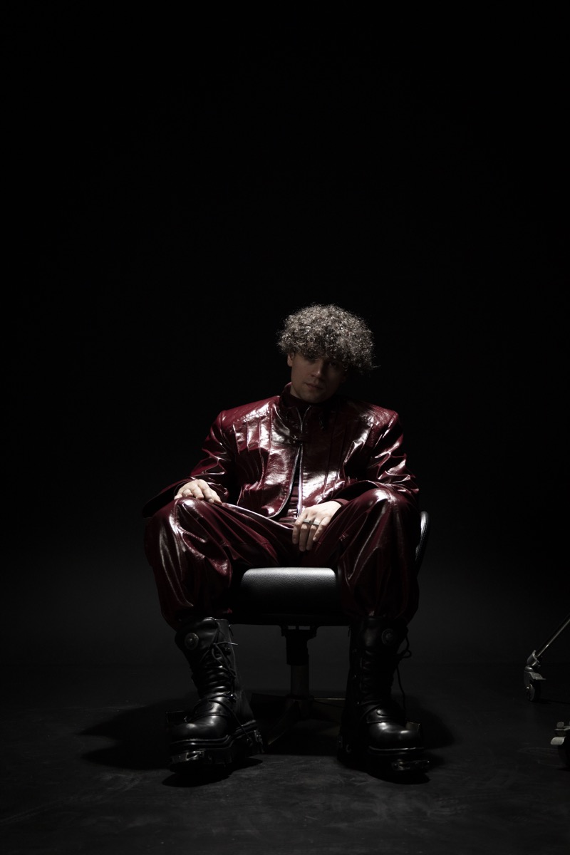 DISTEYO seated portrait — contemplative artist pose